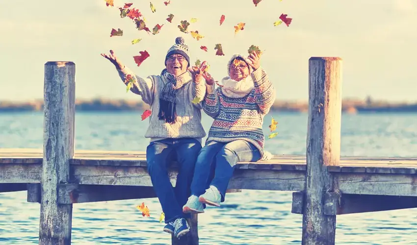 older couple sits on dock symbolizing how Retirement May Be Your Next Adventure